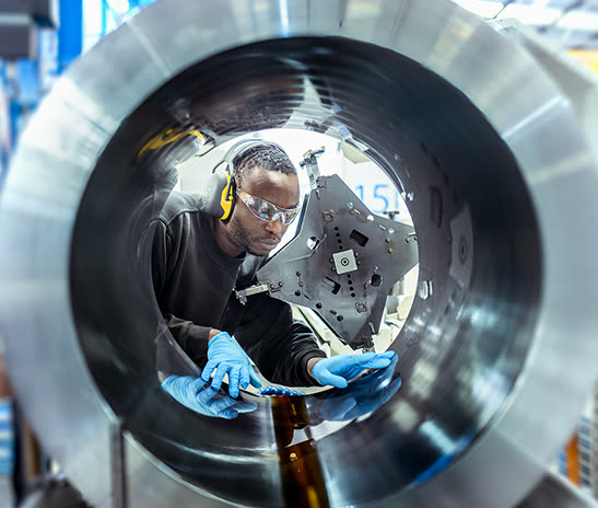 A Hone-All engineer inspecting the bore of a large machined tube